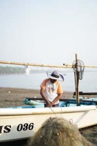 Man in Boat Working with Fishing Net